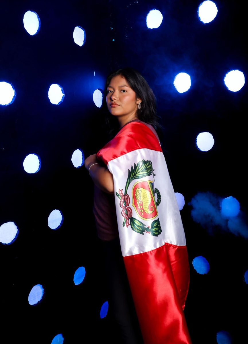 During her sophomore year media day, Adriana Castro poses with the flag, showing her school spirit and confidence. She describes this as one of her favorite photos from the day. (Photo courtesy of CU Sports Information)