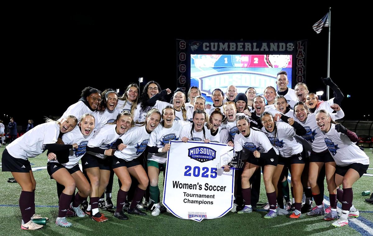Campbellsville University’s women's soccer team celebrates with the conference championship banner after beating University of the Cumberlands 2-1 in overtime on Nov. 11. (Photo by Brett Pierce)