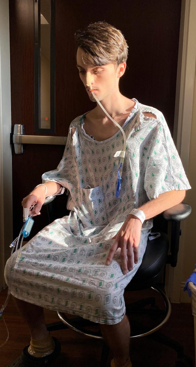 Bryce Osborne takes a break from walking near a hallway window during his hospital stay in December of 2022. Walking was one of the few ways he stayed distracted, often joined by visiting family members.